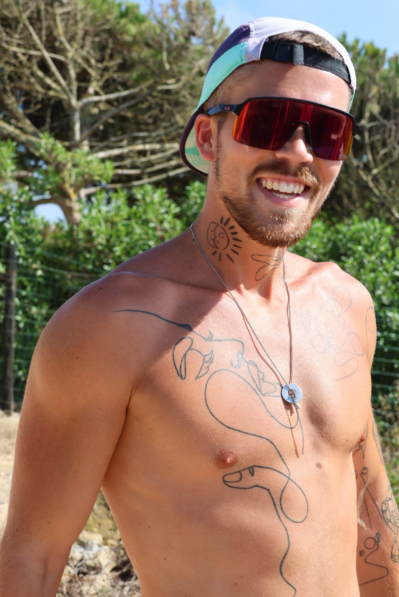 Jonathan Fors smiling in the sun, cap and sunglasses on.